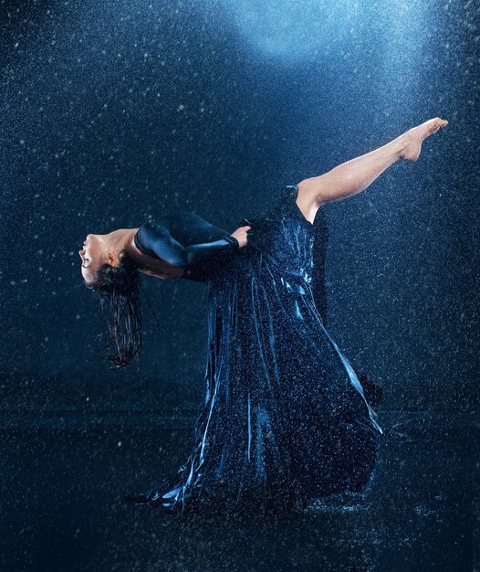 jeune belle danseuse moderne dansant sous les gouttes d'eau