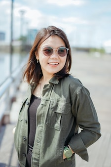 Jeune belle femme asiatique portant une veste et un jean noir posant à l'extérieur
