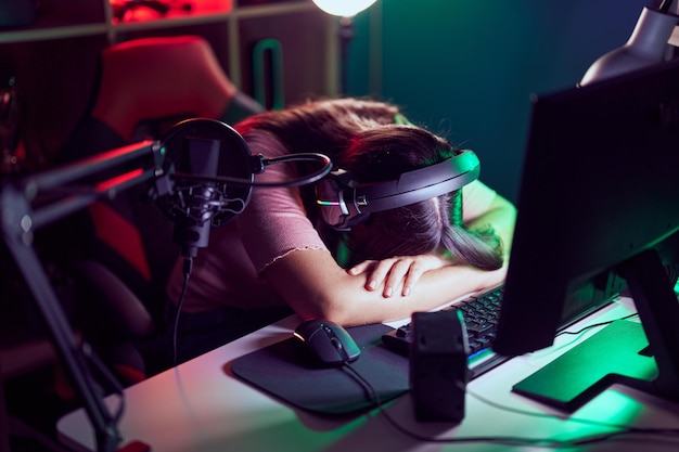 Photo gratuite jeune belle femme hispanique streamer stressée à l'aide d'un ordinateur dans une salle de jeux