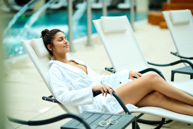 Jeune belle femme en peignoir passant une journée de détente au spa