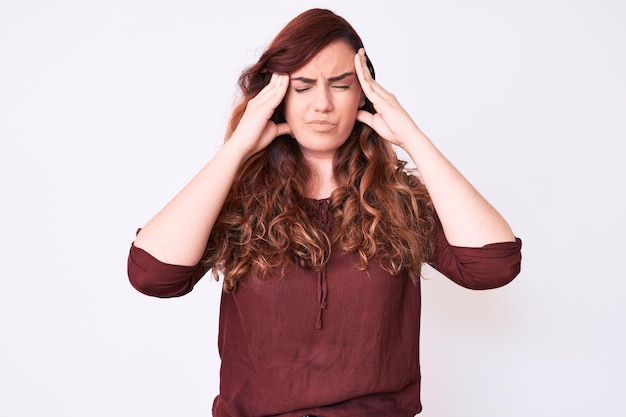 Jeune belle femme portant des vêtements décontractés souffrant de maux de tête désespérés et stressés parce que la douleur et la migraine ont les mains sur la tête