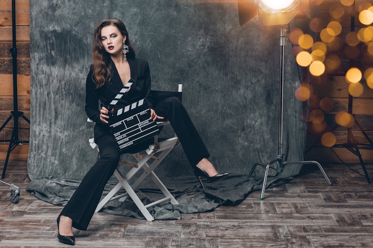 Photo gratuit jeune belle femme sexy élégante sur les coulisses du cinéma, tenant le battant de film