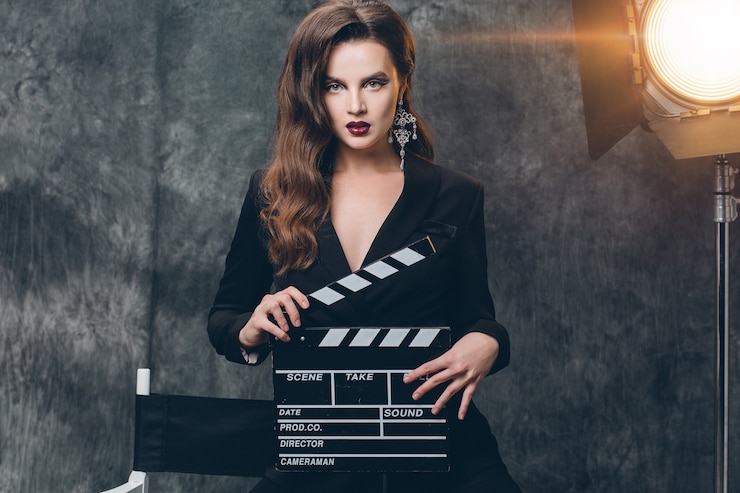 Photo gratuit jeune belle femme sexy élégante sur les coulisses du cinéma, tenant le battant de film