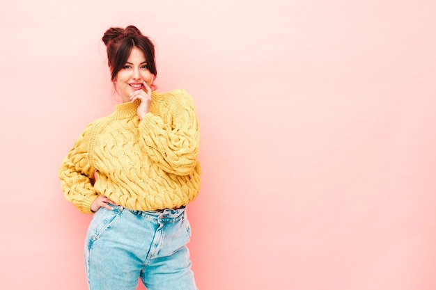 Jeune belle femme souriante en jean et pull hipster jaune d'été à la mode