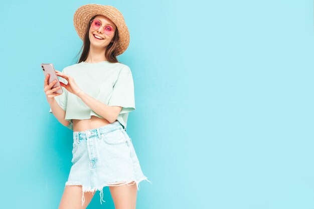 Jeune belle femme souriante en jupe d'été à la mode Femme sexy posant près d'un mur jaune en studio