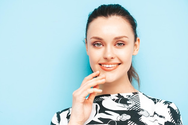 Jeune belle femme souriante en jupe d'été à la mode et vêtements de dessus Sexy femme insouciante posant près du mur bleu en studio Modèle brune positive s'amusantGai et heureux