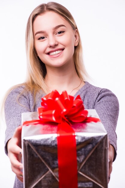 Jeune belle fille avec un cadeau isolé sur un mur blanc.