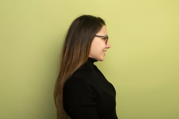 Jeune belle fille dans un col roulé noir et des lunettes