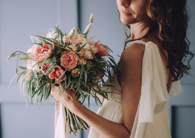 jeune belle fille dans une robe chic avec un bouquet de fleurs