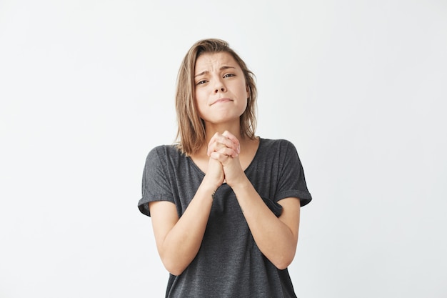 Jeune belle fille émotive priant en espérant.