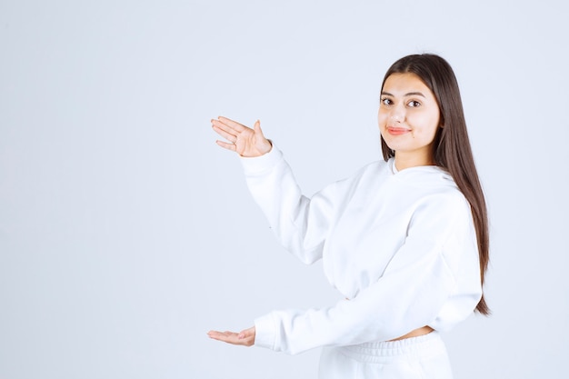 Jeune belle fille gesticulant avec les mains montrant un signe de grande et grande taille.