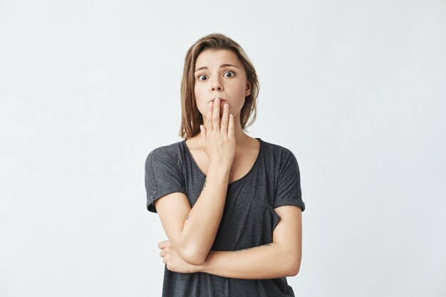 Jeune belle fille honteuse couvrant la bouche avec la main.