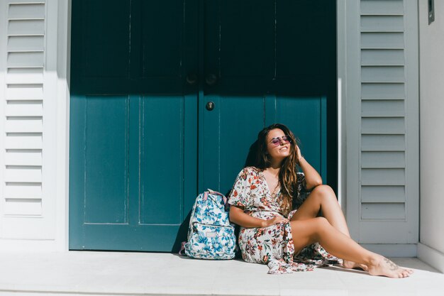 jeune belle fille posant dans la rue dans une robe avec un sac à dos