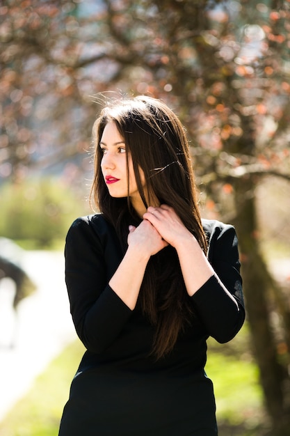 Jeune belle fille posant dans une veste en cuir noire en parc