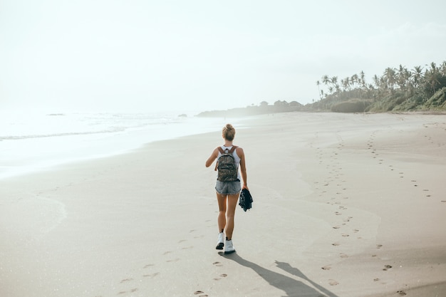 jeune belle fille posant sur la plage, l&#39;océan, les vagues, le soleil et la peau bronzée
