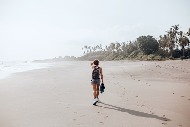 jeune belle fille posant sur la plage, l&#39;océan, les vagues, le soleil et la peau bronzée