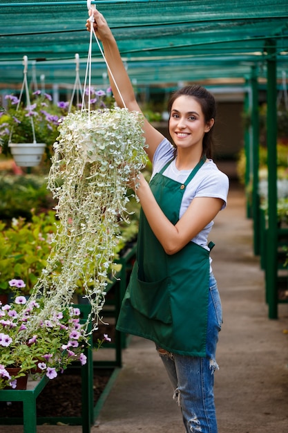 Jeune belle fleuriste en prenant soin des fleurs.