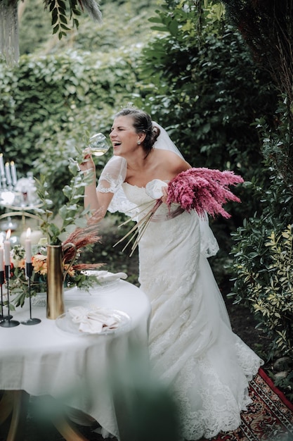 Jeune belle mariée tenant un bouquet dans un style bohème