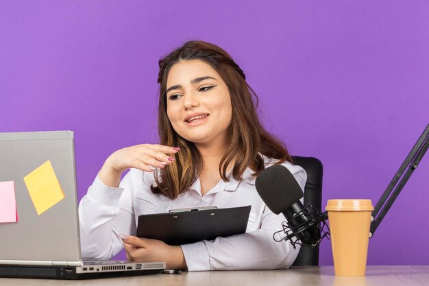 Jeune belle présentatrice de radio travaillant sur pc Photo de haute qualité