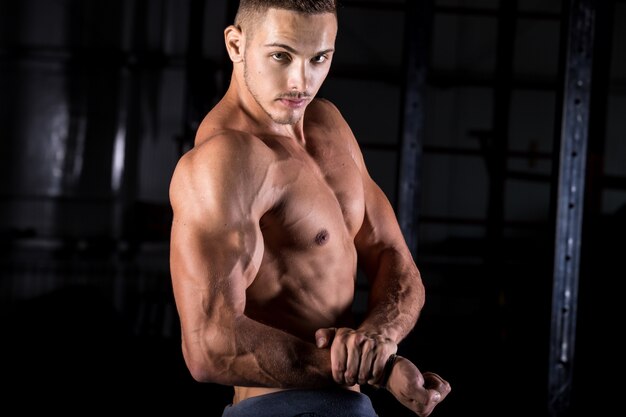 Jeune bodybuilder montrant de forts biceps