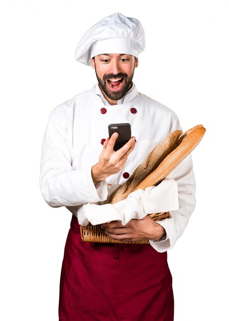 Le jeune boulanger prend du pain et parle au mobile