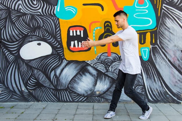 Photo gratuite jeune breakdancer danse contre texturé peint