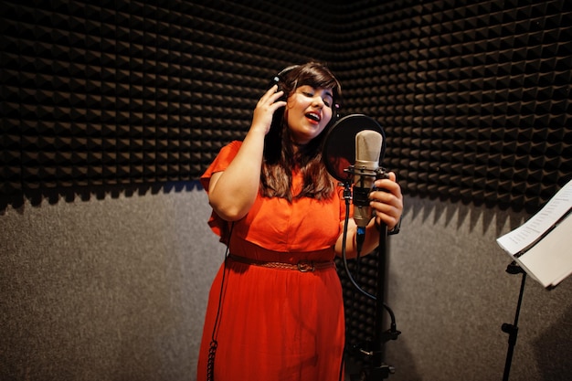 Jeune chanteuse asiatique avec microphone enregistrant une chanson dans un studio de musique d'enregistrement