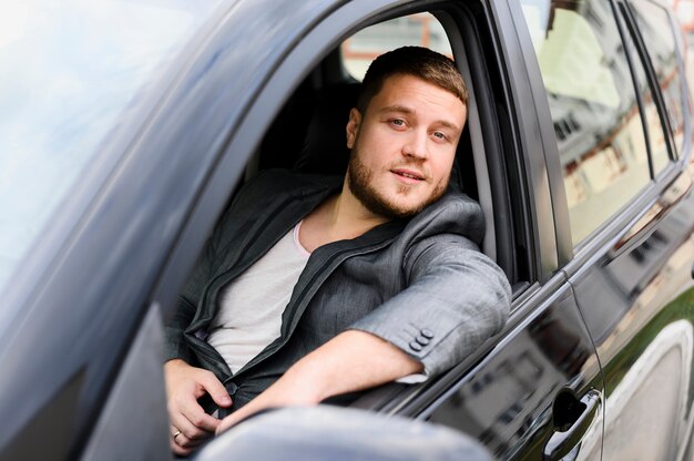 Jeune conducteur avec la fenêtre de la voiture ouverte