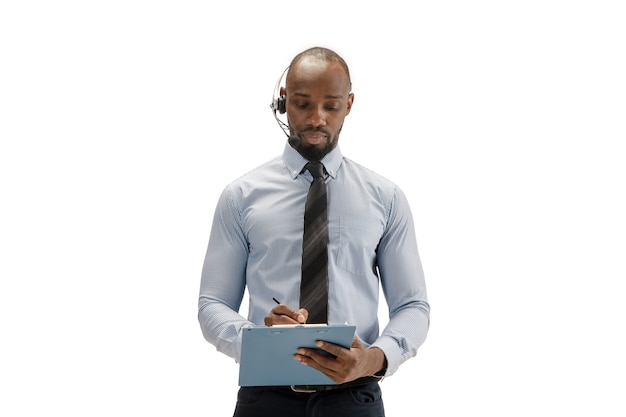 Jeune consultant en centre d'appels afro-américain avec casque isolé sur studio blanc