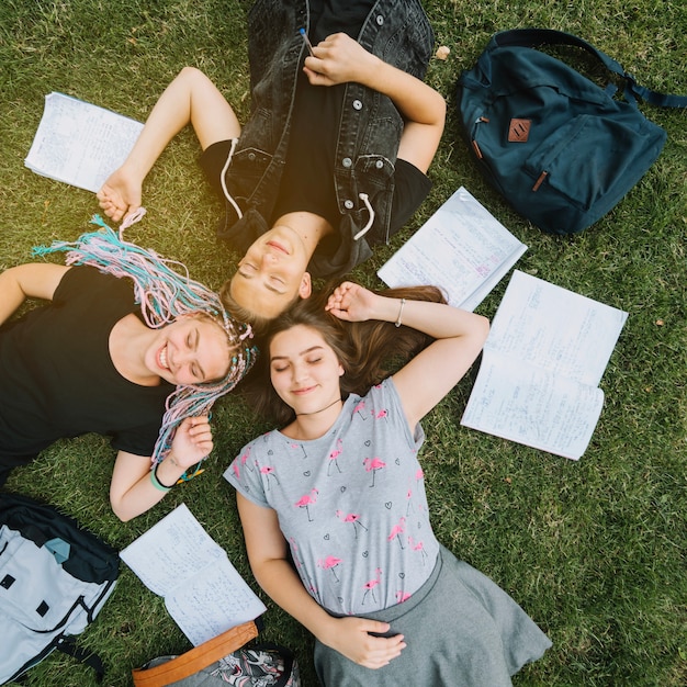 Jeune couple allongé dans un parc avec un livre