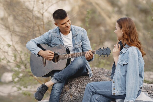 Jeune couple amoureux, petit ami jouant de la guitare