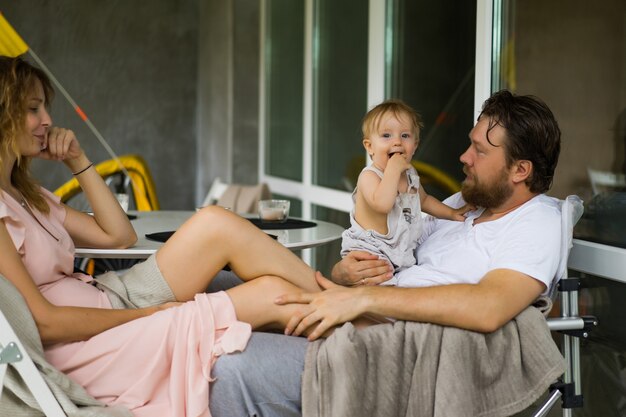 jeune couple amoureux d&#39;un petit enfant sur la terrasse de sa maison.