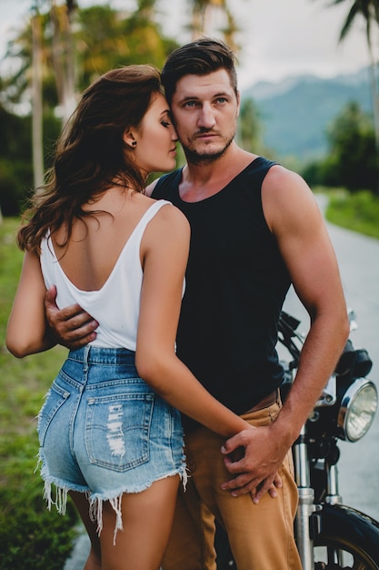 Jeune couple amoureux près d'une moto