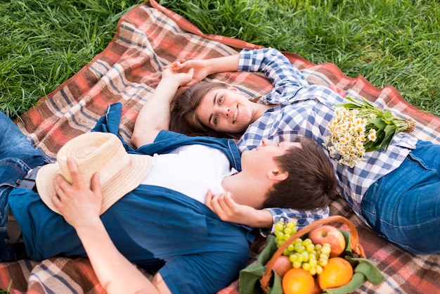 Jeune couple amoureux se trouvant ensemble sur une couverture