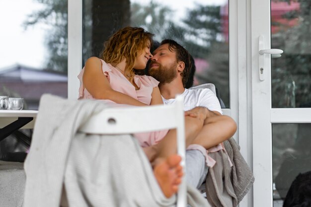 Jeune couple amoureux sur la terrasse de leur maison.