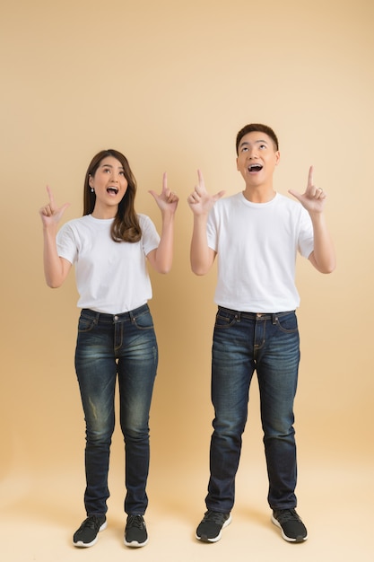 Jeune couple asiatique heureux présentant les symboles de la maison