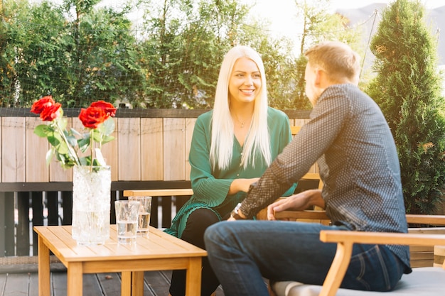 Photo gratuite jeune couple assis sur un balcon en train de passer du temps ensemble