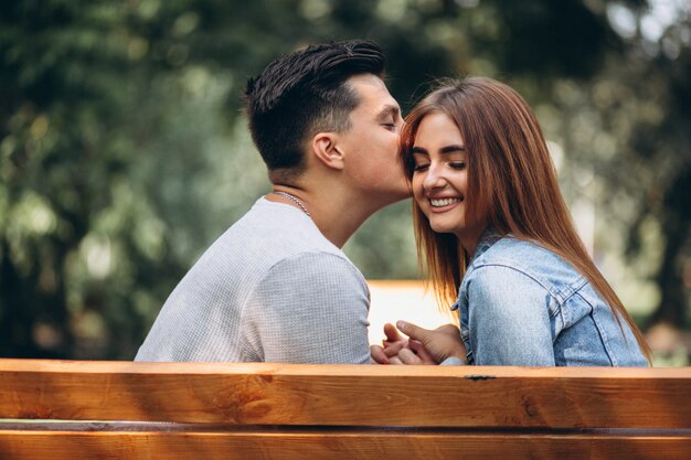 Jeune couple assis sur un banc dans le parc