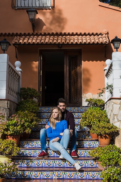 Jeune couple assis sur le porche