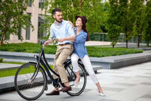 Jeune couple assis sur un vélo