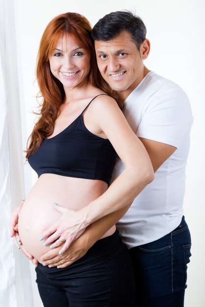 Un jeune couple attend un bébé. Isolé sur blanc.