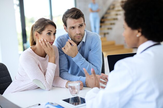 Jeune couple ayant des conseils médicaux avec un médecin à la clinique