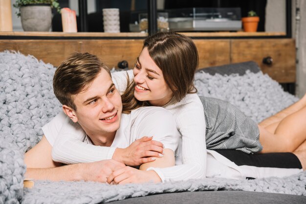 Jeune couple en blanc allongé sur un canapé