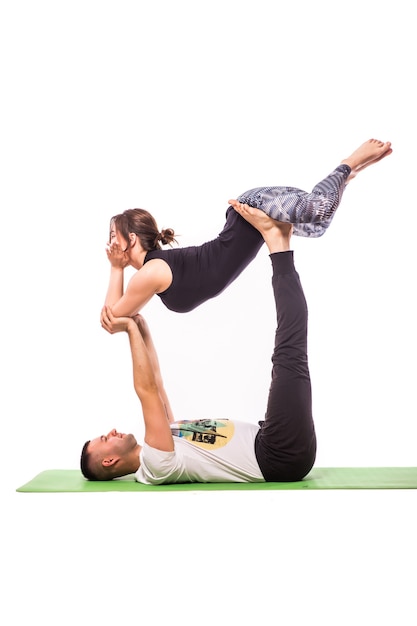 Jeune couple en bonne santé en position d'yoga isolé sur fond blanc