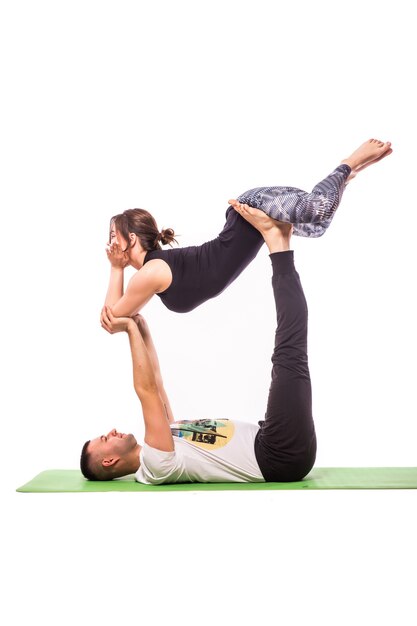 Jeune couple en bonne santé en position d'yoga isolé sur fond blanc