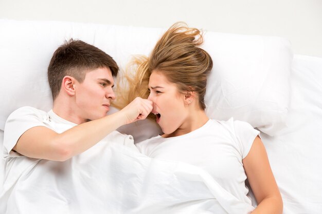 Le jeune couple charmant allongé dans un lit