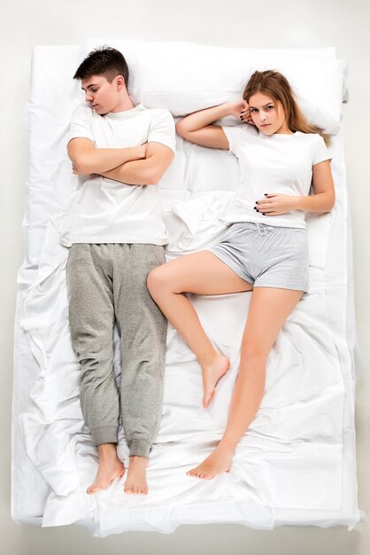 Le jeune couple charmant couché dans un lit