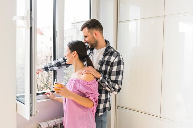 Jeune couple cherche par la fenêtre à la maison