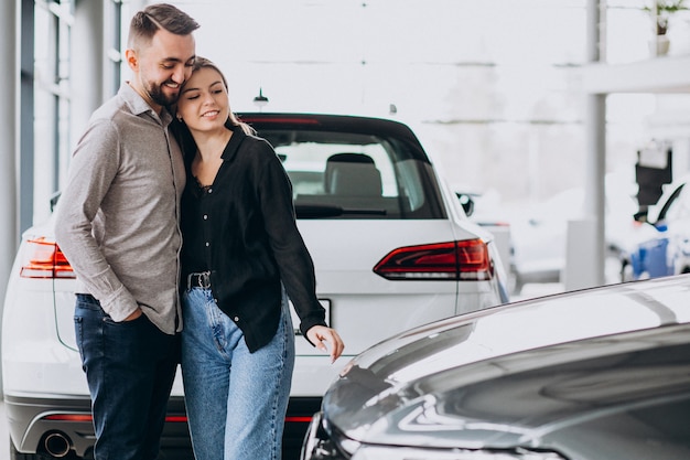 Jeune couple, choisir, a, voiture, dans, a, exposition voiture, salle