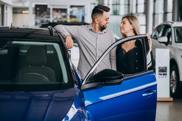 Jeune couple, choisir, a, voiture, dans, a, exposition voiture, salle